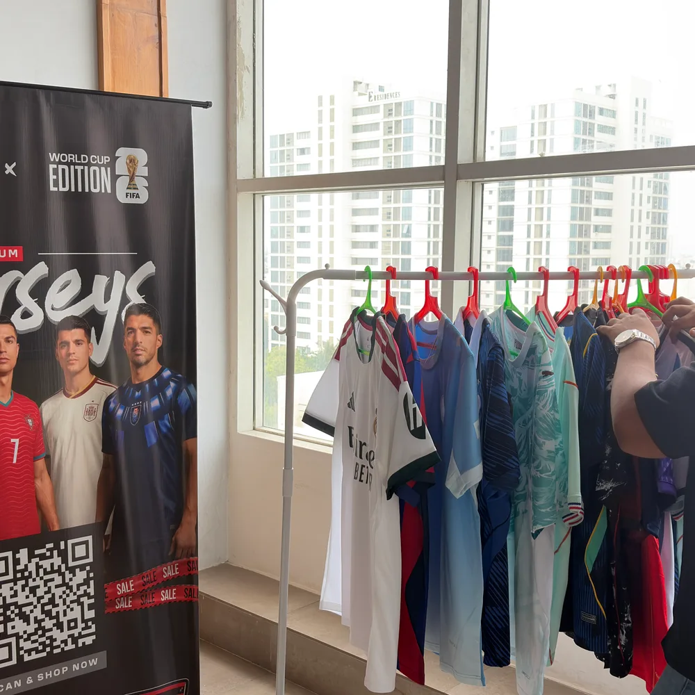 A clothing display with a Jersey brand sign and product rails